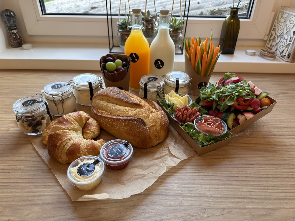 Reggelicsomag friss kenyérrel, croissant-nal, lekvárral és salátával